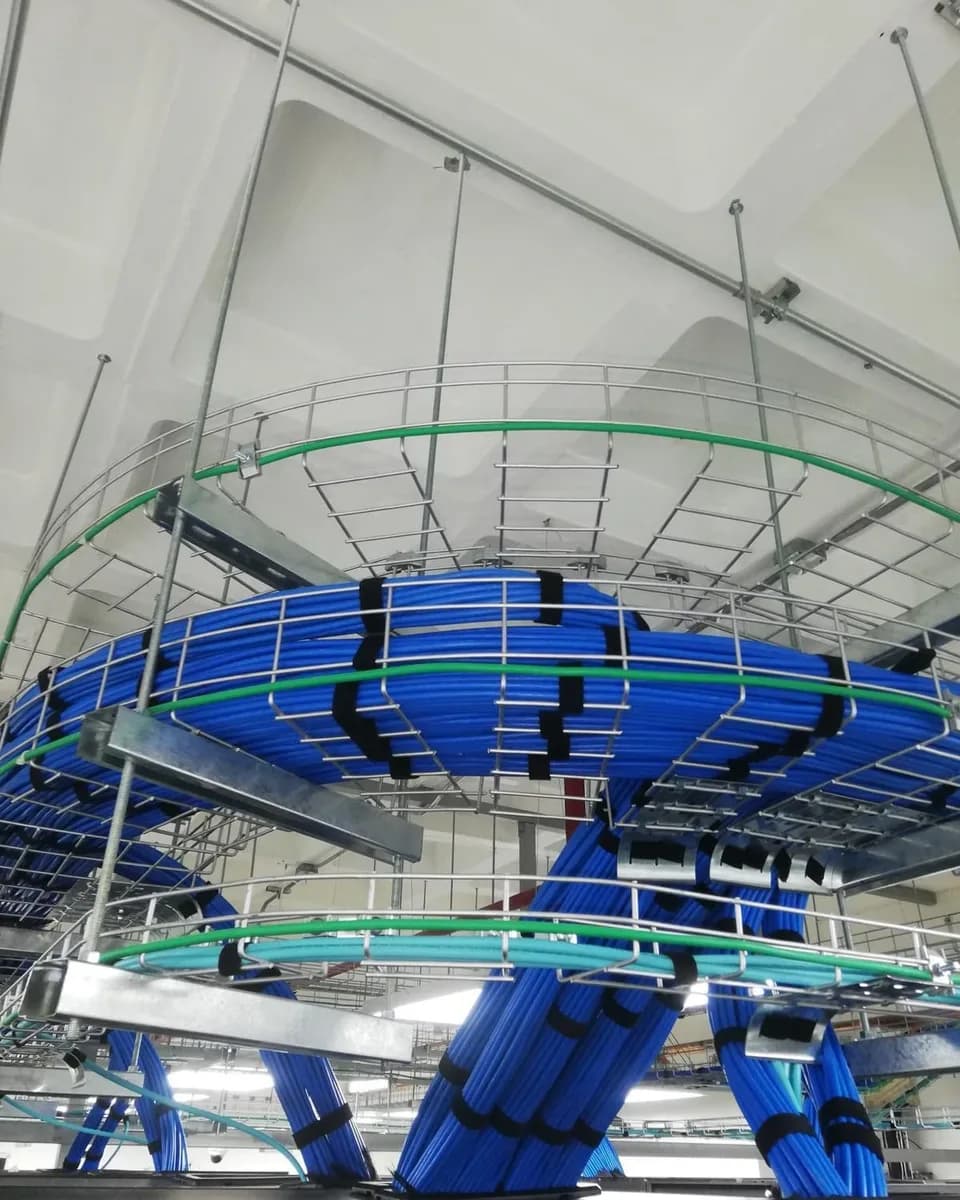 Spiral cable tray above Bancaribe's datacenter in Caracas, with blue Cat6A copper trunks and green and aqua fiber.