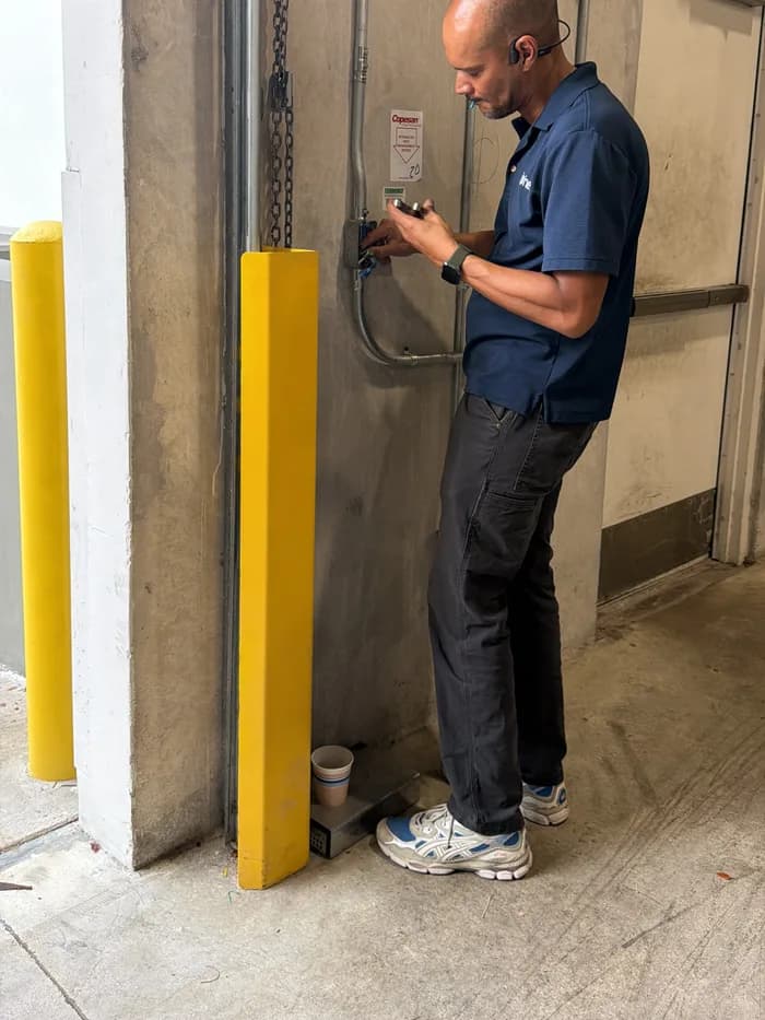 An Insinet technician wiring a low-voltage panel next to a loading dock door.